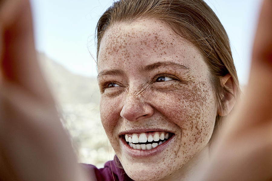 Portrait of laughing young woman with freckles outdoors Photograph by Westend61
