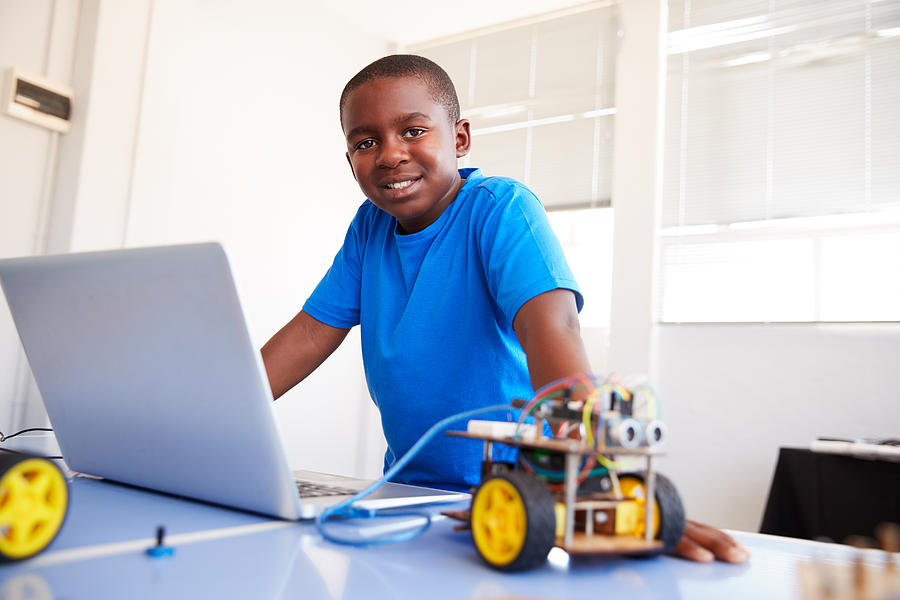 Portrait Of Male Student Building And Programing Robot Vehicle In School Computer Coding Class Photograph by Monkeybusinessimages