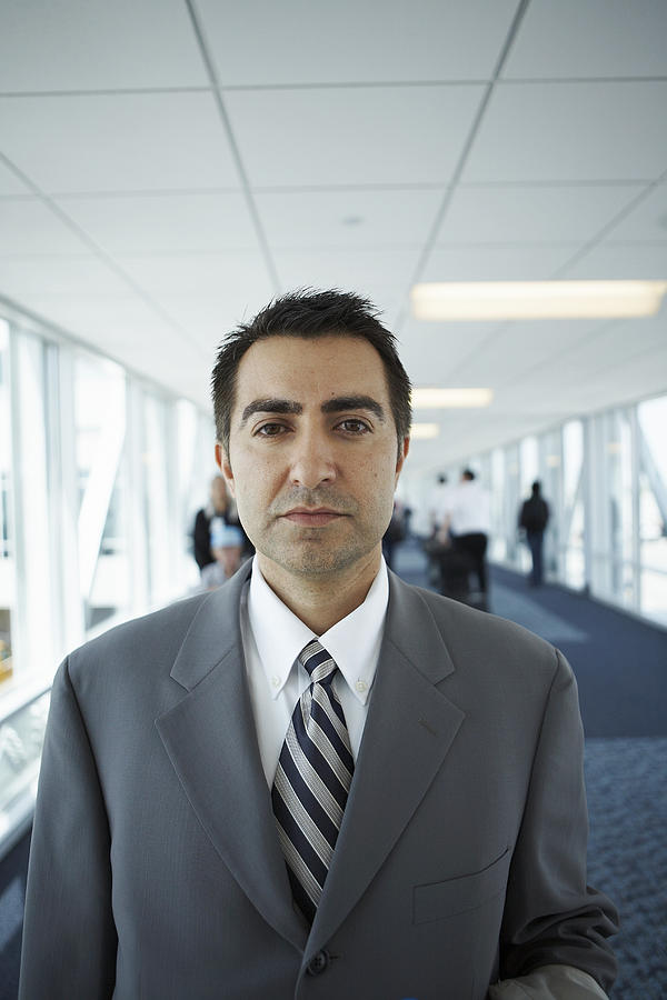 Portrait of mid adult business man in airport Photograph by Stewart Sutton