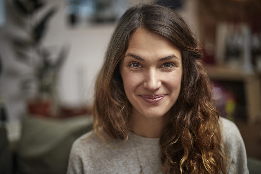 Portrait of smiling brunette woman at home Photograph by Oliver Rossi