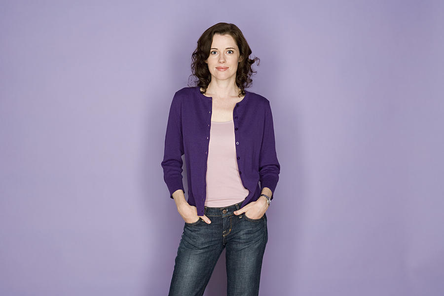 Portrait of smiling woman on purple background, studio shot Photograph by Rob Lewine