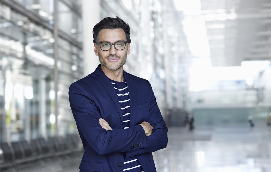 Portrait of stylish businessman with stubble wearing blue suit and glasses Photograph by Westend61