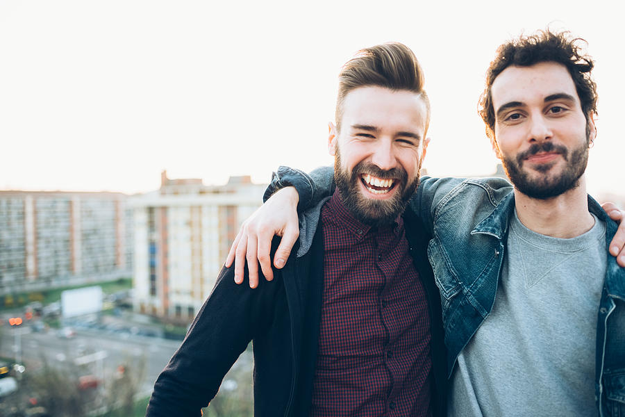 Portrait of two young men, on roof, smiling Photograph by Eugenio Marongiu