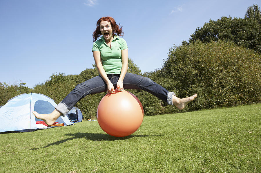 Portrait of woman bouncing on rubber ball Photograph by Flashpop