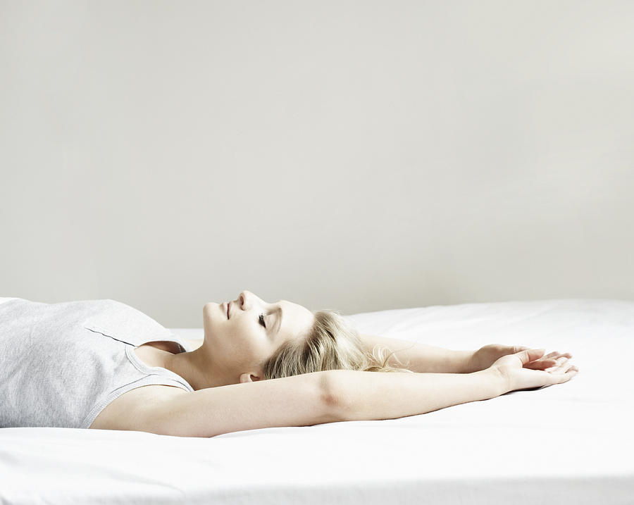 Portrait of woman lying on bed Photograph by Flashpop