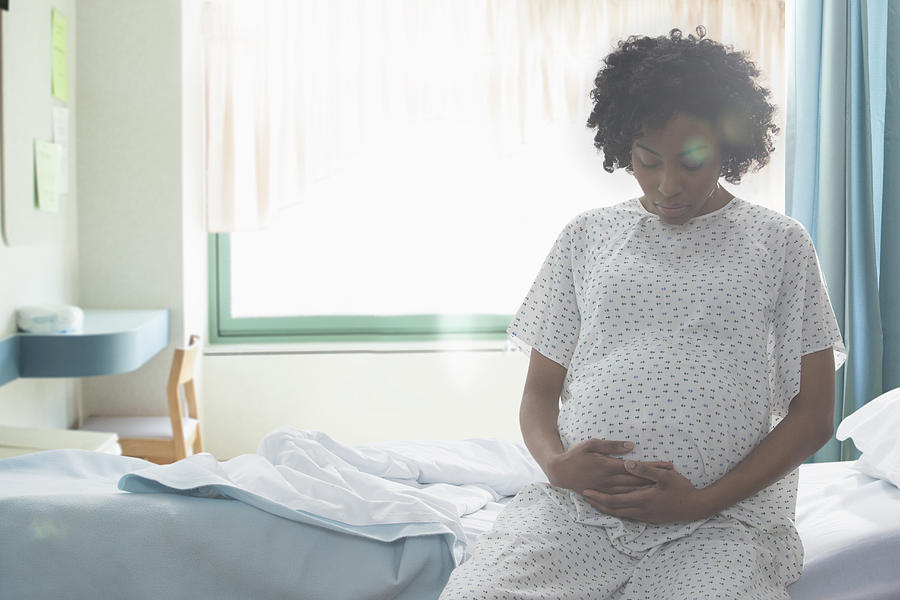 Pregnant African American woman holding her stomach in hospital Photograph by Jose Luis Pelaez Inc