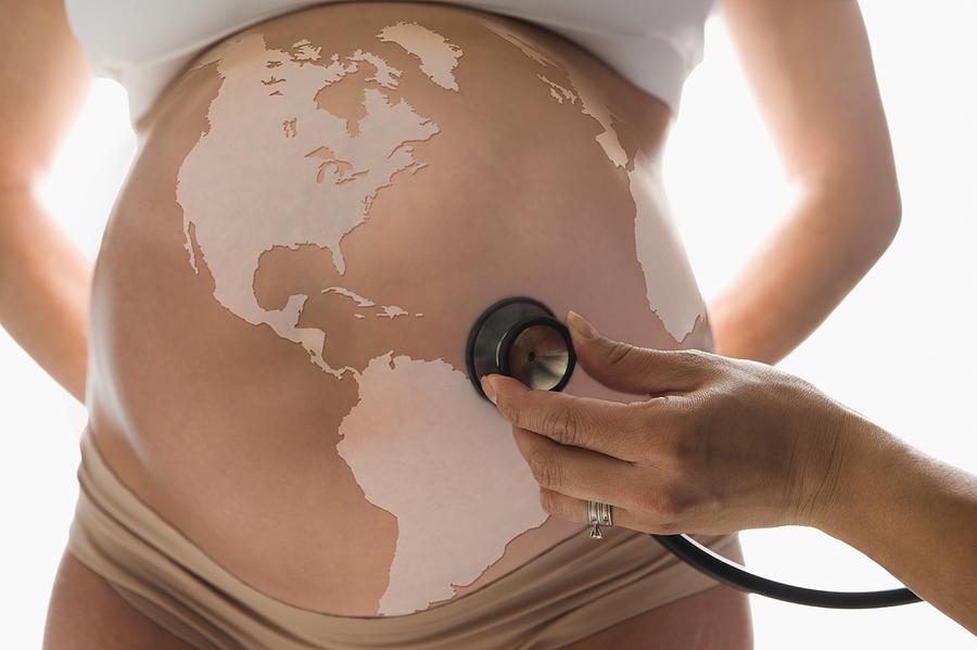 Pregnant Hispanic woman with globe on belly Photograph by Jose Luis Pelaez Inc