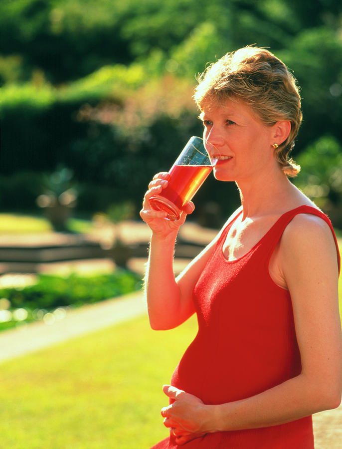 Juice Photograph - Pregnant Woman Drinking A Glass Of Juice by Damien Lovegrove/science Photo Library