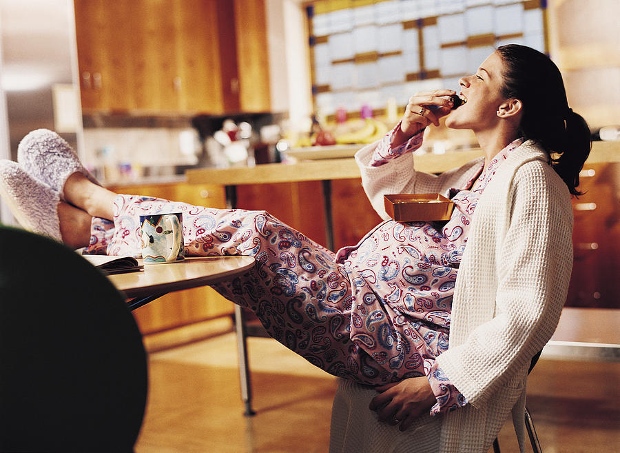 Pregnant Woman Eating Chocolate Photograph by Cohen/Ostrow