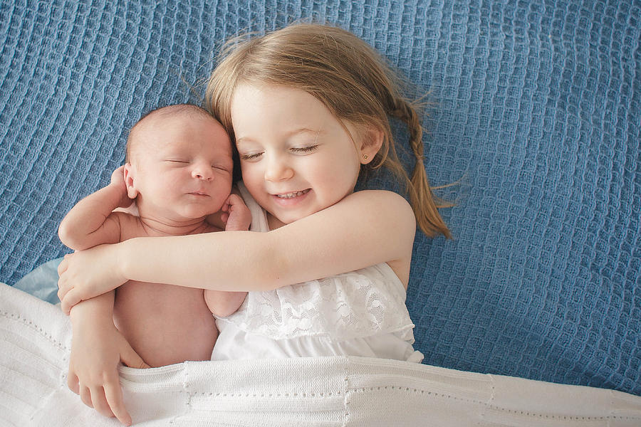 Preschool Girl Hugs Newborn Baby Brother Photograph by Shannon Banal