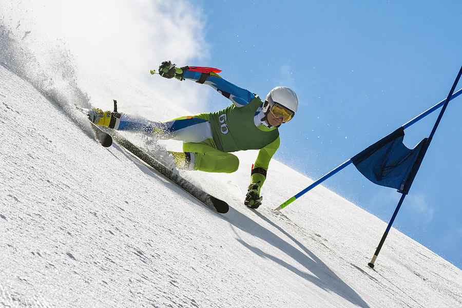 Professional Alpine Skier Compeeting at Giant Slalom Race Against the Blue Sky Photograph by Technotr