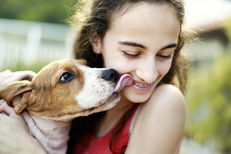 Puppy kissing teenage girl Photograph by MaFelipe