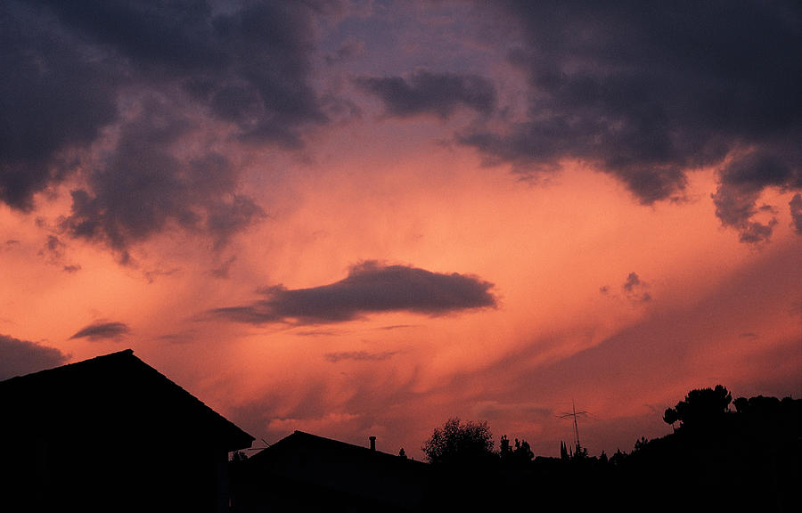 Purple Clouds Gather In A Pink Sky Above Dark Houses Photograph by Photodisc