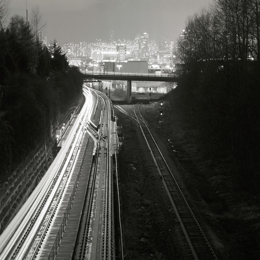 Railway Tracks Leading To City Skyline Photograph by Brian Caissie