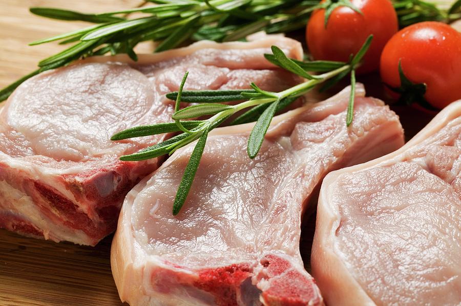 Raw Pork Chops With Rosemary And Tomatoes Photograph by Foodcollection.