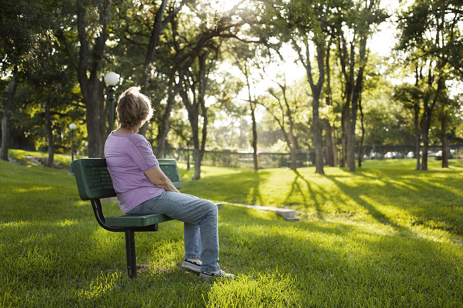 Rear view of mature woman sitting on park bench.  Summer. Photograph by Fstop123