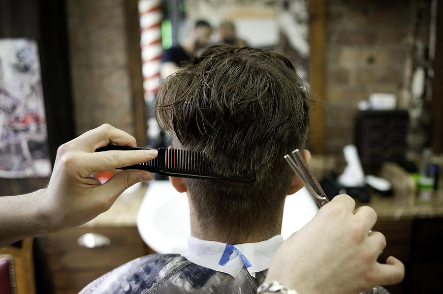 Rear view of young man in barbershop having haircut Photograph by Rogan Macdonald