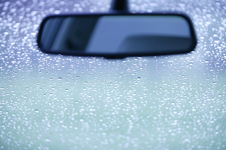 Rearview mirror and rain on a windshield Photograph by Comstock