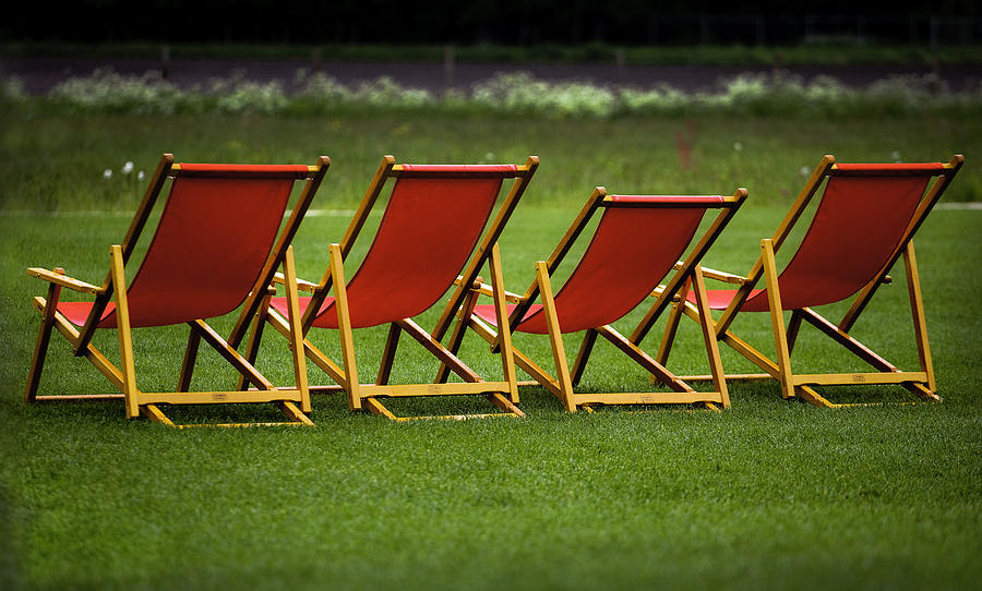 Lounge Photograph - Red deck chairs on the green lawn by Mikhail Pankov