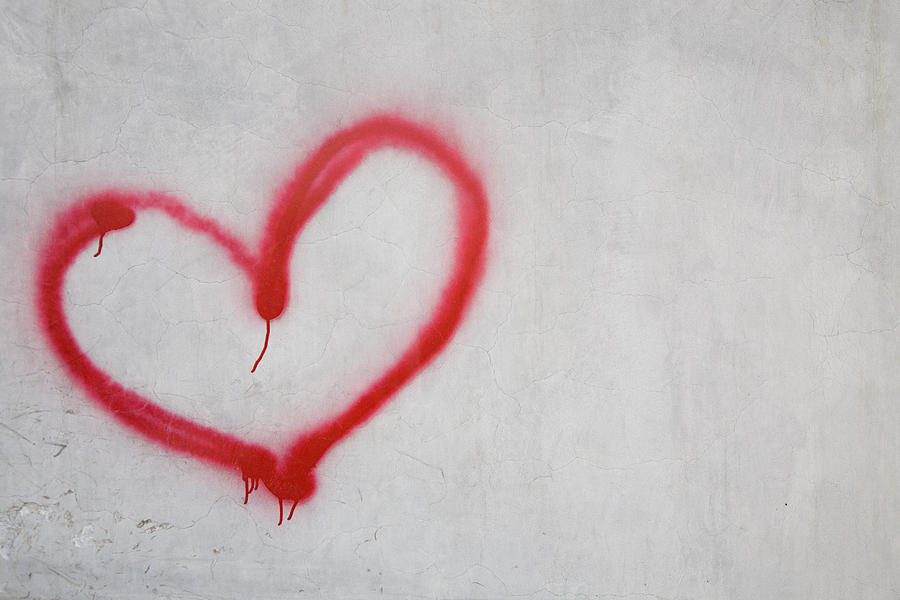 Red heart shape on white wall Photograph by Image Source