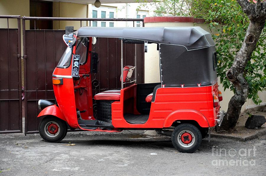 Red three wheeler tuk tuk rickshaw parked outside gate Colombo Sri Lanka Photograph by Imran Ahmed