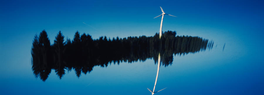 Nature Photograph - Reflection Of A Wind Turbine And Trees by Panoramic Images