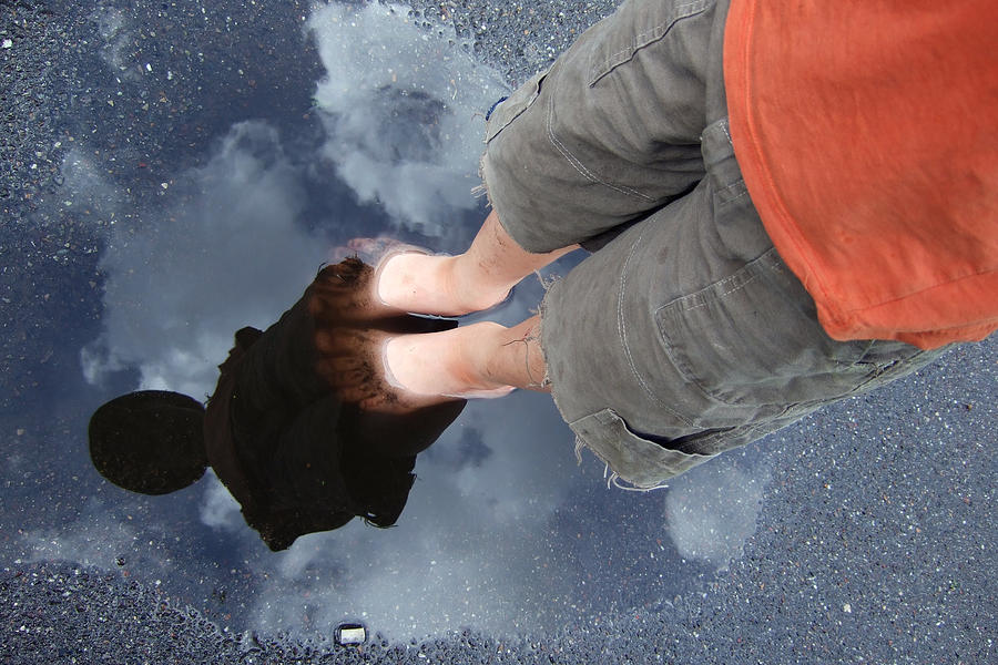 Reflection of boy in a puddle of water Photograph by Matthias Hauser