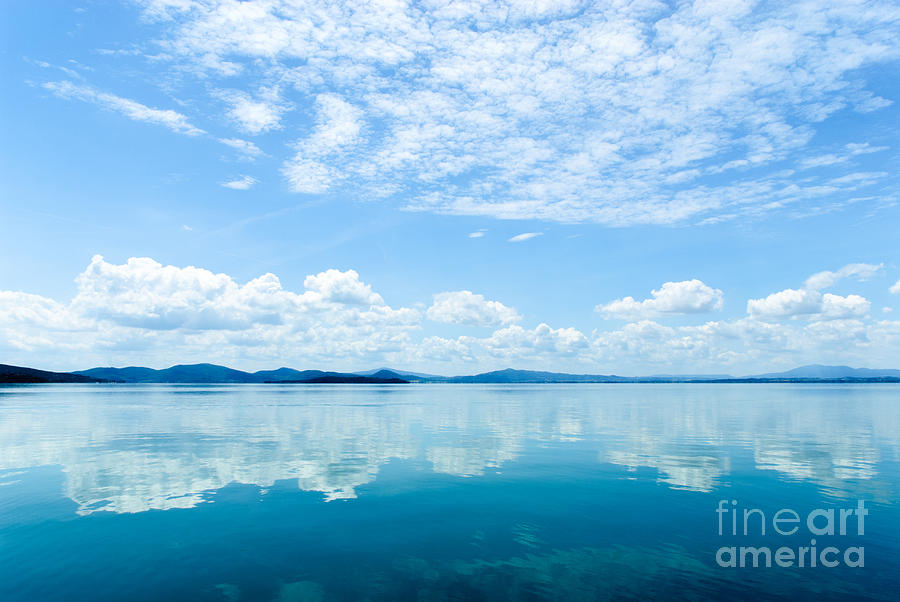 Reflection of clouds in Lake Trasimeno Photograph by Peter Noyce