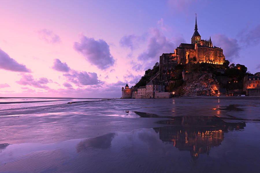 Reflections of Mont Saint-Michel Lit in the Evening Photograph by JurgaR