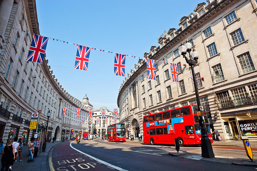 Regents St with red buses and bunting Photograph by Kokoroimages.com