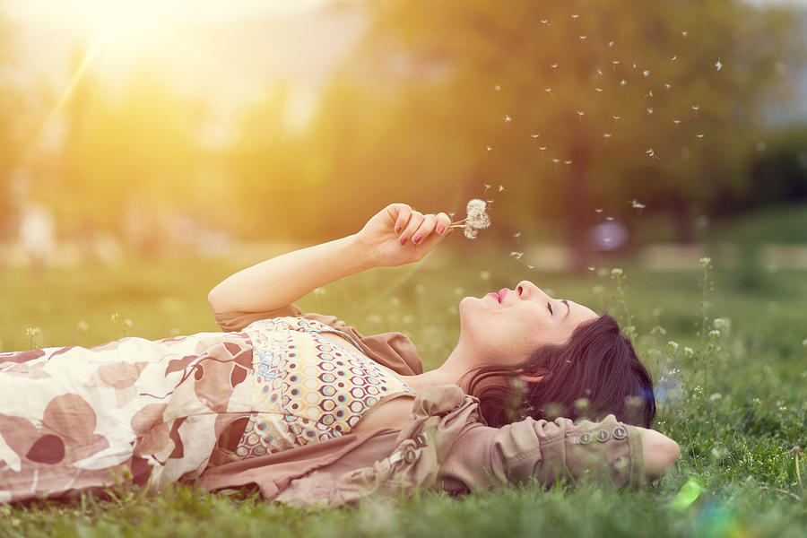 Relaxed woman in the park blowing dandelion Photograph by Martin-dm