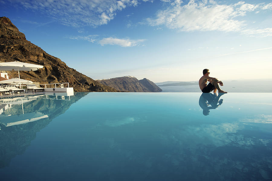 Relaxing Man Sitting Edge Luxury Resort Infinity Pool Santorini Greece Photograph by PeskyMonkey
