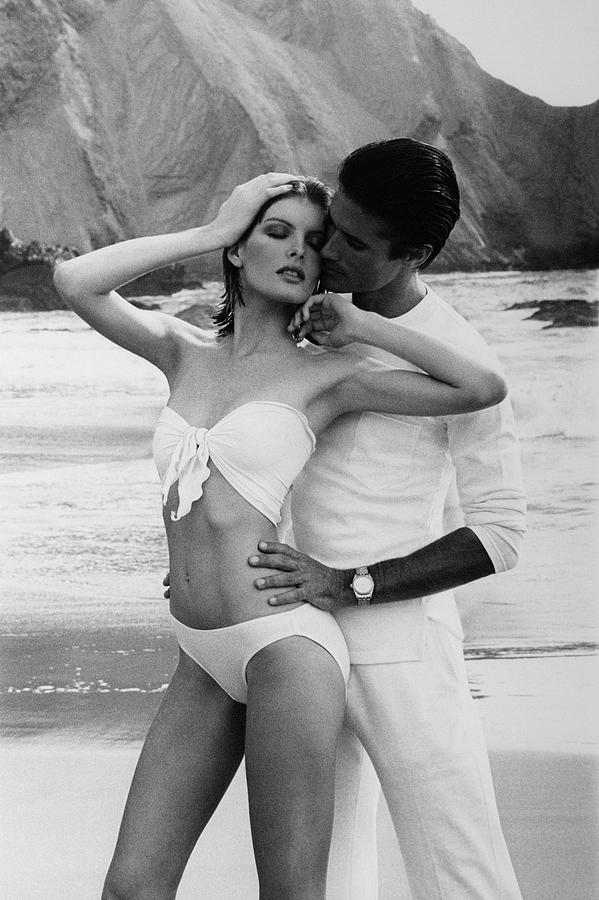 Rene Russo Posing With A Male Model On A Beach Photograph by Francesco Scavullo
