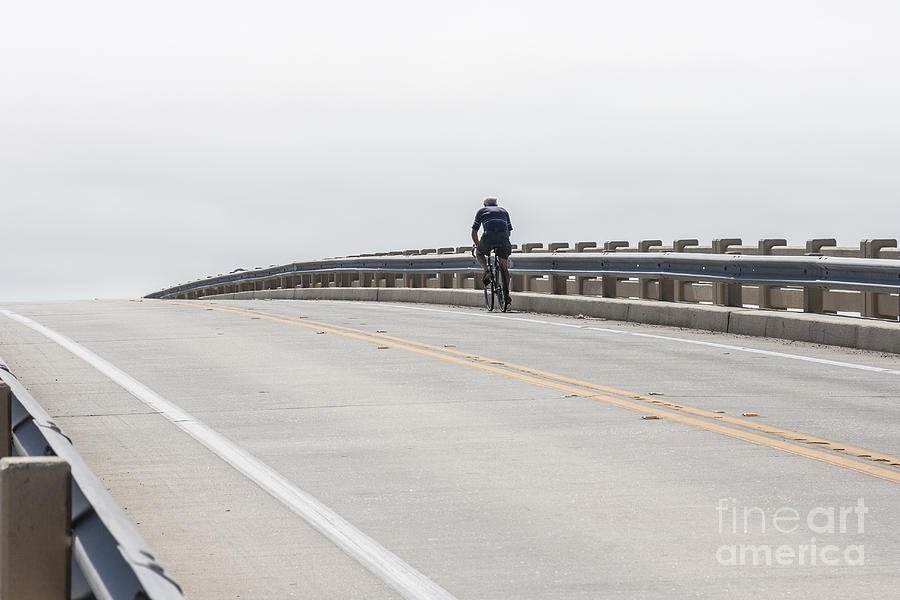 A Cyclist Rides over a Bridge into the Horizon Photograph by William Kuta