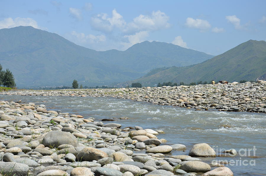 Riverbank water rocks mountains and a horseman Swat Valley Pakistan Photograph by Imran Ahmed