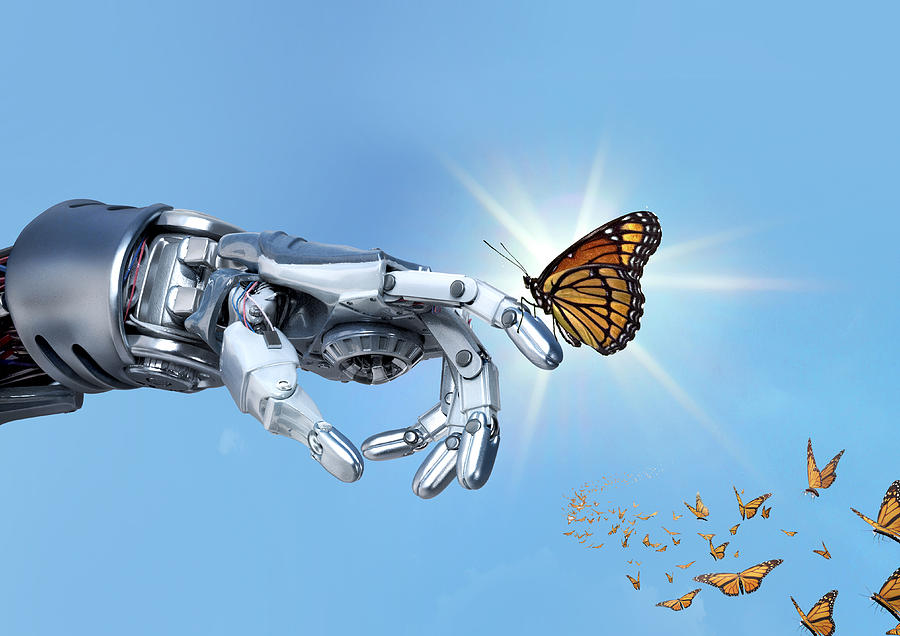 Robot hand holding an orange monarch butterfly Photograph by Paper Boat Creative
