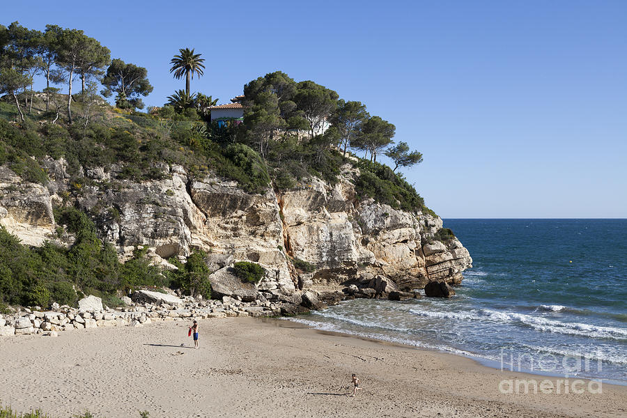rocky inlet cove and beach of Cap Salou Photograph by Peter Noyce