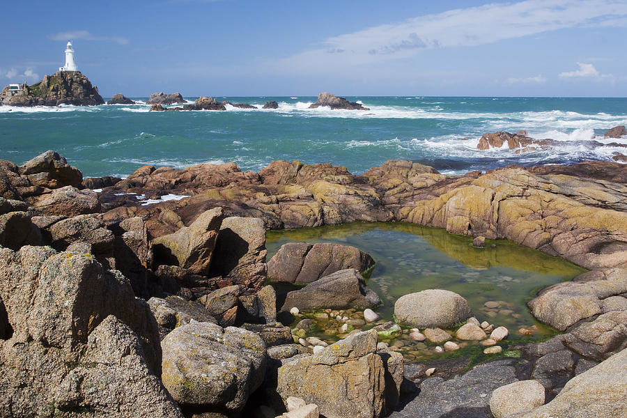 Rocky Shore And La Corbiere Lighthouse Photograph by Bill Coster