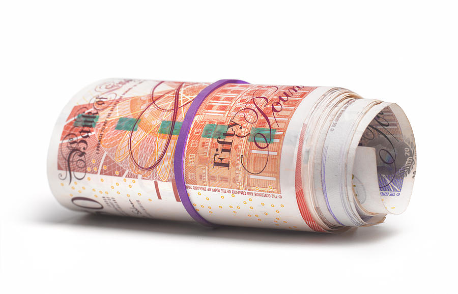 Roll of UK bank notes Photograph by Peter Dazeley