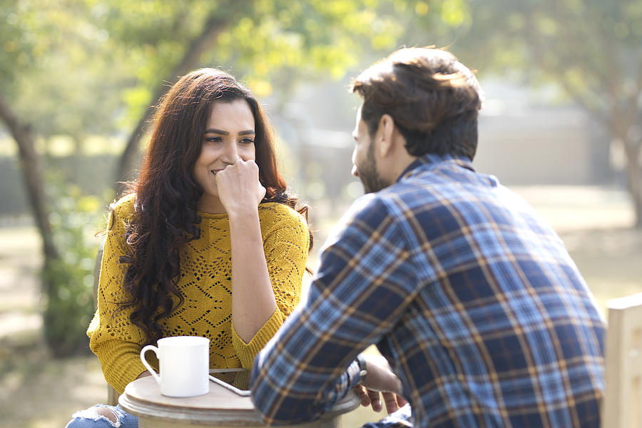 Romantic Indian couple having coffee at park Photograph by Triloks