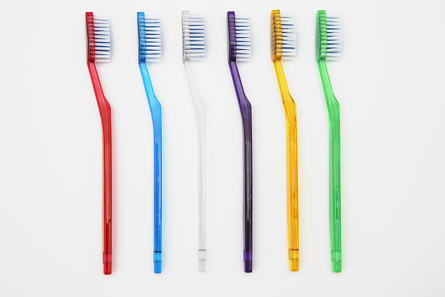 Row of multi-coloured toothbrushes Photograph by Raimund Koch