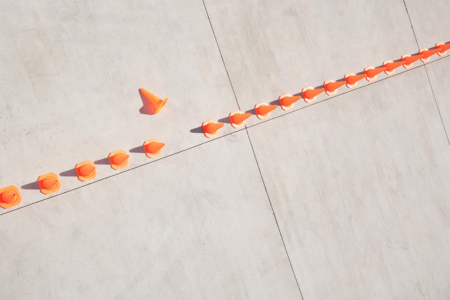 Row of traffic cones with one on side Photograph by Martin Barraud
