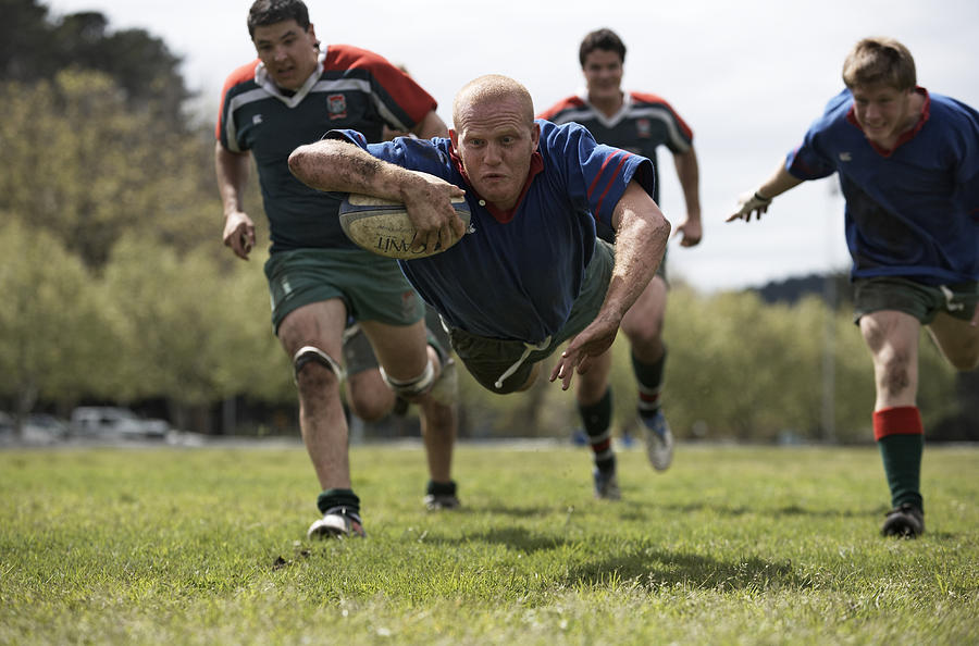 Rugby player scoring jumping on groud with ball Photograph by Alistair Berg