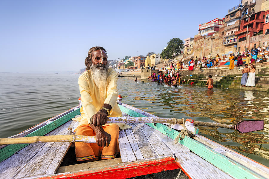 Sadhu rowing boat on the holy Ganges River in Varanasi Photograph by Hadynyah