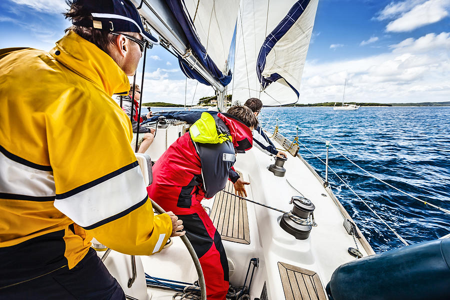 Sailing crew beating to windward on sailboat Photograph by Mbbirdy