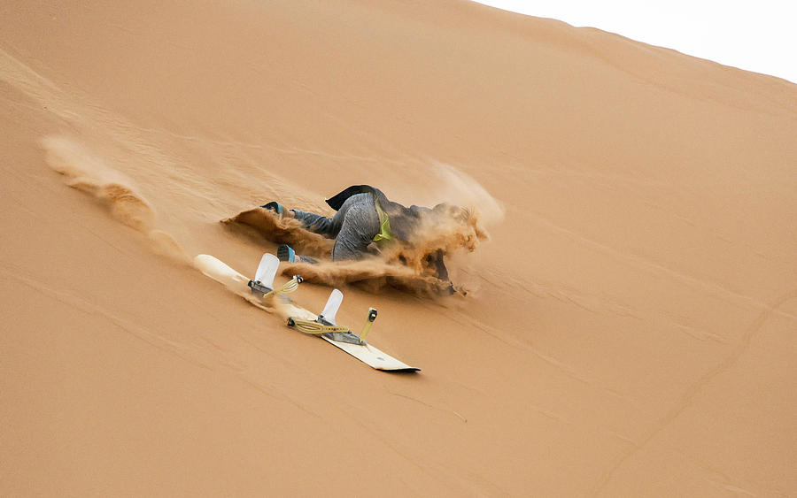 Sand-boarding the Saharan sand dunes, Merzouga, Morocco Photograph by Paul Biris