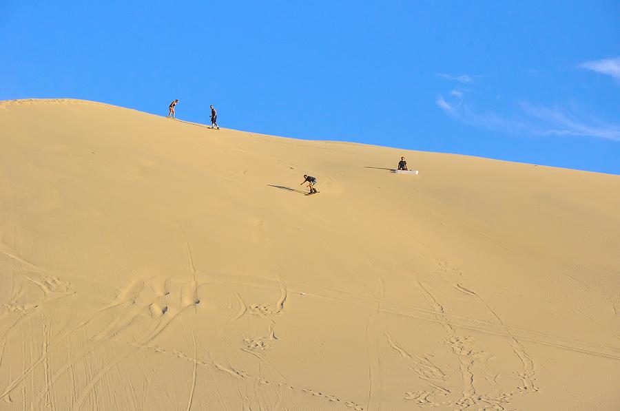 Sand surfing in the dunes near Huacachina, Peru Photograph by Markus Daniel
