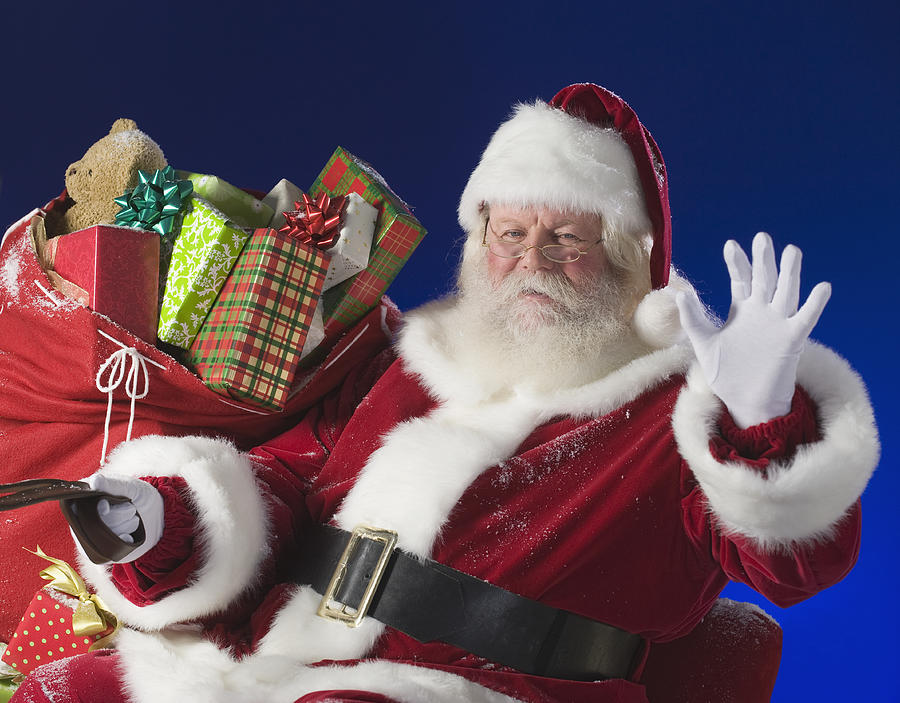 Santa Claus next to bag of toys Photograph by Tetra Images
