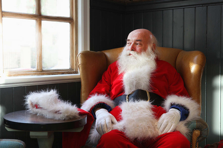 Santa Claus taking break in armchair Photograph by Daniel Allan