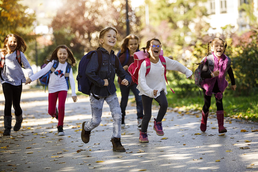 School kids running in schoolyard Photograph by Damircudic School kids running in schoolyard Photograph by Damircudic